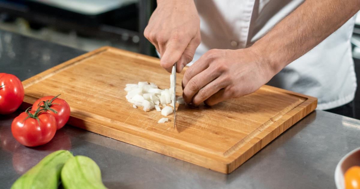 Espetinhos de carne sobre tábua de madeira com farofa de limão e pimenta