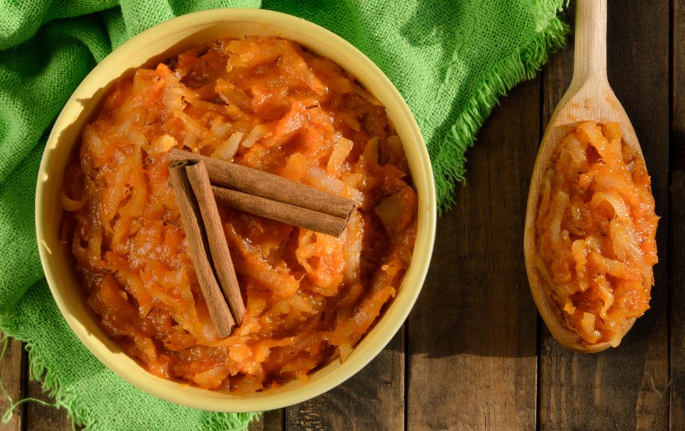 Sobremesa brasileira doce de abóbora coco e canela em uma tigela e mesa de  madeira