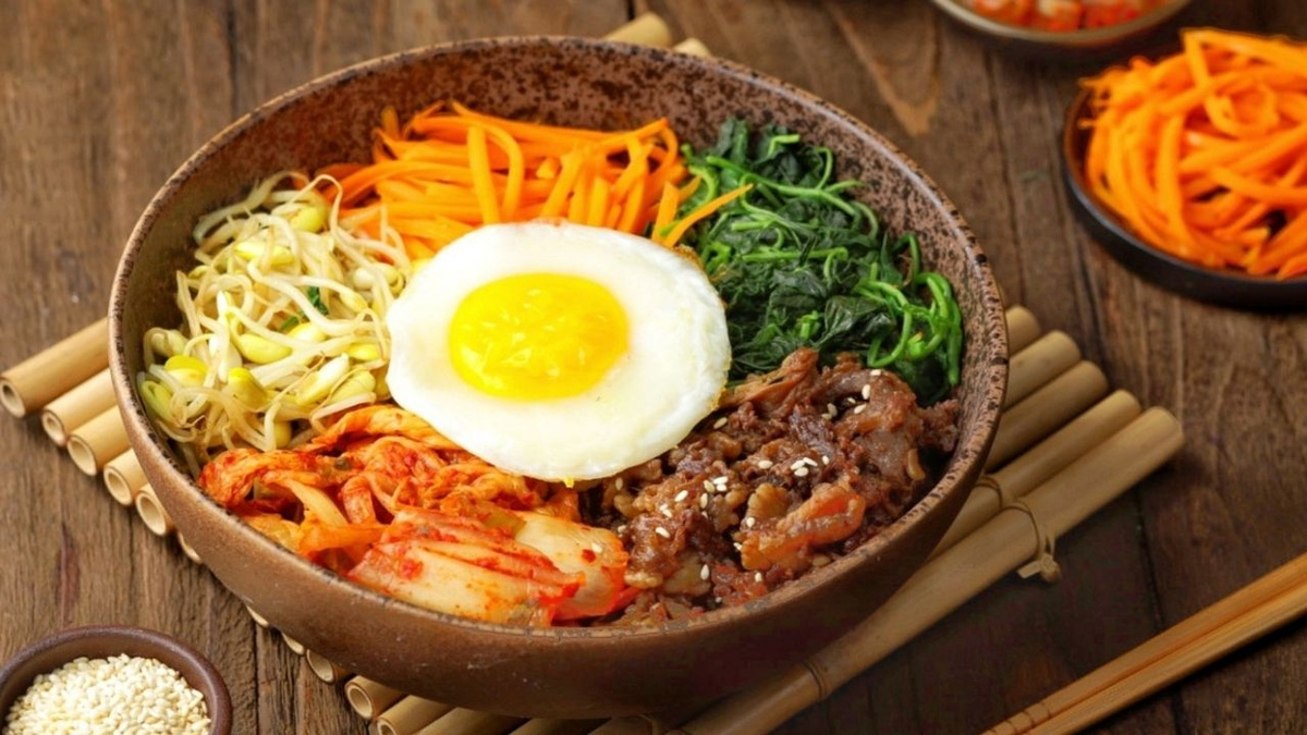 Bibimbap tradicional coreano de arroz misturado com carne, legumes e ovo frito