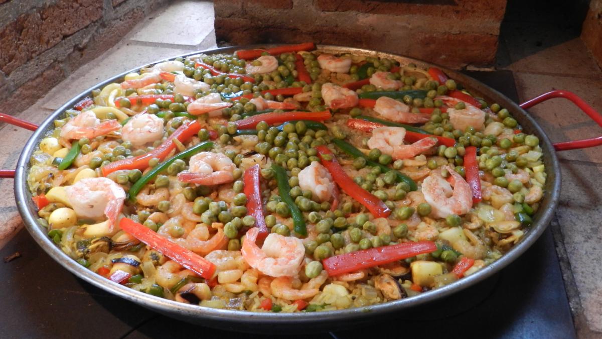 paella com frango e frutos do mar na chapa branca. prato espanhol