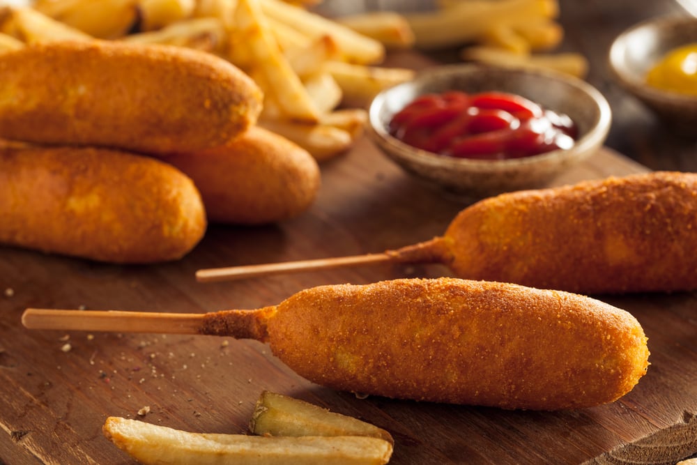 Corn dog é uma salsicha no palito com queijo mussarela, revestida com massa  de farinha e frita. comida de rua coreana de cachorro-quente