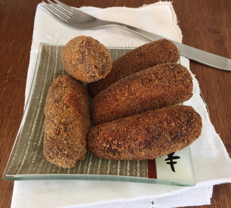 Croquete caseiro tradicional espanhol no garfo com fundo escuro