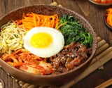 Bibimbap tradicional coreano de arroz misturado com carne, legumes e ovo frito