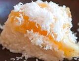 Bolo podre de tapioca gelado com cobertura diferente de doce de bacuri e coco ralado