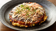 Okonomiyaki panqueca salgada japonesa recheada e finalizada com molho agridoce