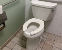 Para que serve a abertura frontal em formato de U nos vasos sanitários de banheiros públicos?