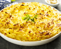 Bacalhau com natas gratinado em uma prato redondo grande