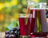 Suco de uva concentrado caseiro na jarra e no copo ao ar livre