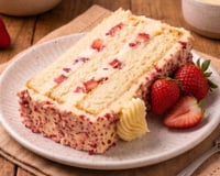 Fatia de bolo de morango cravejado: doce viral tem massa fofinha, recheio cremoso e cobertura crocante