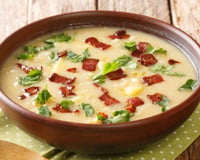 Sopa de mandioca com bacon finalizada com folhas
