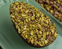 Ovo de Páscoa de pistache coberto com pedaços da oleaginosa