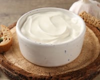 Creme de alho cremoso servido em recipiente com torradinhas