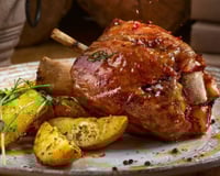 Pernil assado com batata rústica e temperos no prato completo