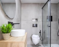 Especialistas em reformas e designers de interiores concordam: "Em banheiros pequenos, o box ideal deve ser fixo e transparente, e a base do chuveiro deve estar nivelada com o piso e ter uma cor semelhante à do piso."