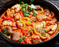 Moqueca baiana com postas de peixe e pimentões fatiados