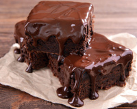 Bolo fofinho de chocolate com cobertura cremosa.