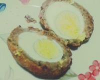 Ovo à milanesa envolvido em linguiça