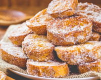 Rabanada assada empilhada e polvilhada de açúcar e canela