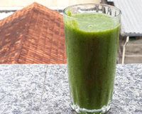Suco verde detox no copo de vidro ideal para um dia quente