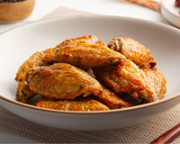 Tulipas de frango com molho de mostarda e mel em prato branco