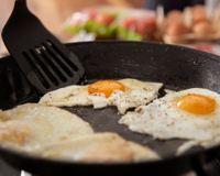 Por que é recomendado colocar vinagre na frigideira ao fritar ovos e qual é o propósito disso?