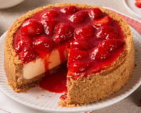 Torta cheesecake com molho de morangos escorrendo do corte