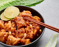 Frango chinês crocante com limão à moda antiga: uma costeleta de frango empanada, cortada em fatias e coberta com um molho de limão doce e picante