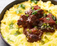 Rabada com polenta e agrião em um prato fundo