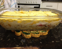 Filé de tilápia ao forno coberto por fatias de queijo em travessa de vidro