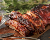 Costelinha de porco temperada cozida e acompanhada de molho