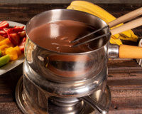 Fondue de chocolate acompanhado por frutas variadas