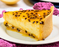 Fatia de cheesecake de maracujá com calda e massa crocante