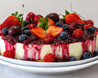 Cheesecake de frutas vermelhas com cobertura e frutas em cima