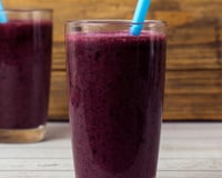 Suco de jabuticaba em copo de vidro servido com canudo