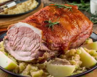 Pernil de porco assado com batatas e ervas para a família