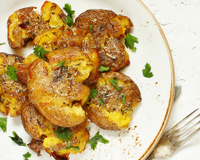 O petisco francês que vai roubar a cena na sua semana: batatinhas amassadas com cebola caramelizada e queijo derretido