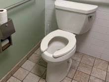Para que serve a abertura frontal em formato de U nos vasos sanitários de banheiros públicos?