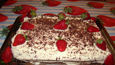 Bolo de chocolate com recheio de flocos e creme com morangos