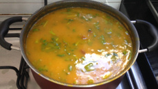 Sopa de abóbora com lâminas de carne seca e talos de agrião