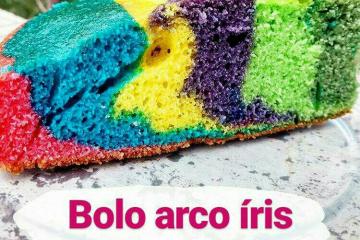 Um bolo roxo com glacê roxo e branco e um arco-íris no topo