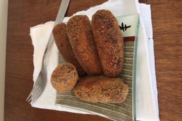 Croquete caseiro tradicional espanhol no garfo com fundo escuro