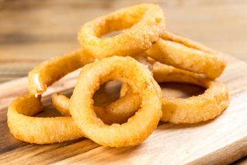 Fígado frito com cebola, batata doce e salada no prato branco