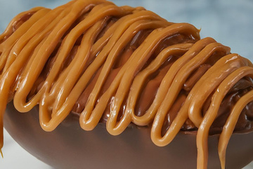 Ovo de chocolate recheado com paletas e coberto com calda de caramelo salgado