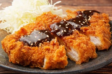 Tonkatsu de porco empanado e frito crocante com molho para acompanhar
