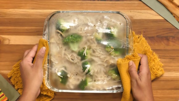 Refratário com macarrão, brócolis e frango coberto com papel-filme recém saído do micro-ondas (Créditos: TudoGostoso)