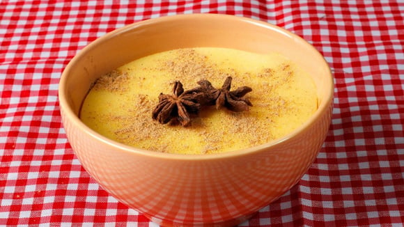 Canjica nordestina de milho verde decorada com canela em pó e cravos (Créditos: Shutterstock)