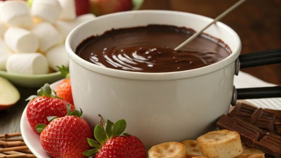 Fondue de chocolate supercremoso em tigela branca com alimentos para mergulhar (Créditos: Shutterstock)