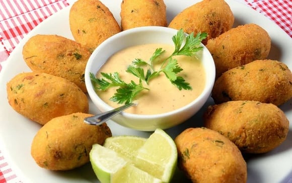 Bolinho de bacalhau acompanhado com um molho não só é pratico de comer como é uma delícia (Créditos: TudoGostoso)