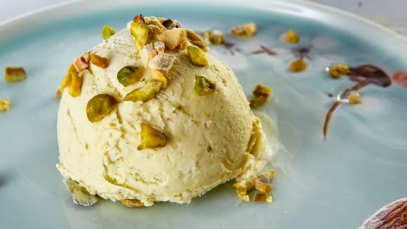 Sorvete de pistache cremoso em um prato finalizado com mais sementes por cima (Créditos: Shutterstock)