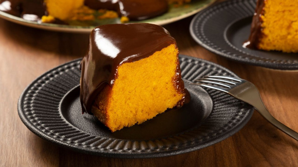Fatia de bolo de cenoura vegano com textura macia e cobertura de chocolate (Créditos: Shutterstock)